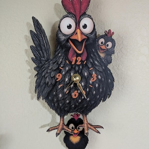 May include: A whimsical wall clock featuring a cartoon chicken family. The clock has a black body with white speckles, a red comb, and orange numbers. The clock hands are gold. A baby chick hangs below the mother hen.