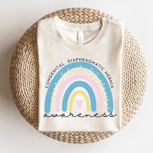 May include: A white t-shirt with a rainbow design and the text "Congenital Diaphragmatic Hernia Awareness".