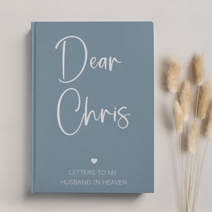 May include: A blue hardcover journal with the text "Dear Chris" in white script. The journal has a small heart symbol and the text "Letters to my Husband in Heaven" in white.
