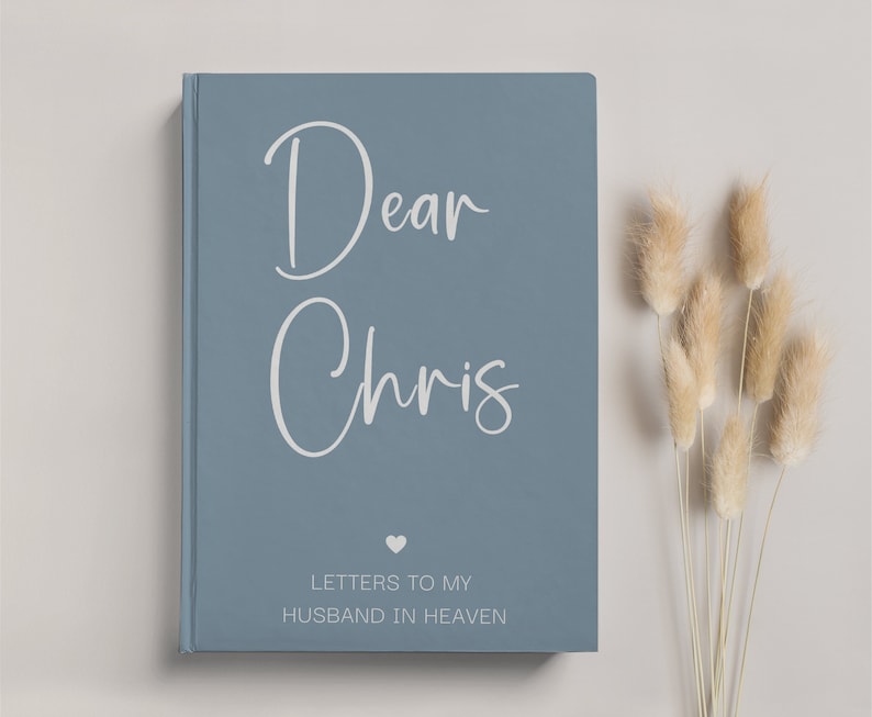 May include: A blue hardcover journal with the text "Dear Chris" in white script. The journal has a small heart symbol and the text "Letters to my Husband in Heaven" in white.