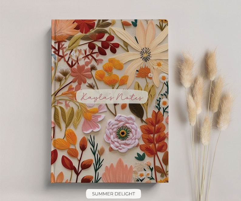 K&ouml;nnte beinhalten: Ein Notizbuchcover mit floralem Muster in Rosa, Orange und Gelb. Das Cover tr&auml;gt den Text "Kayla's Notes" in rosa Schrift.