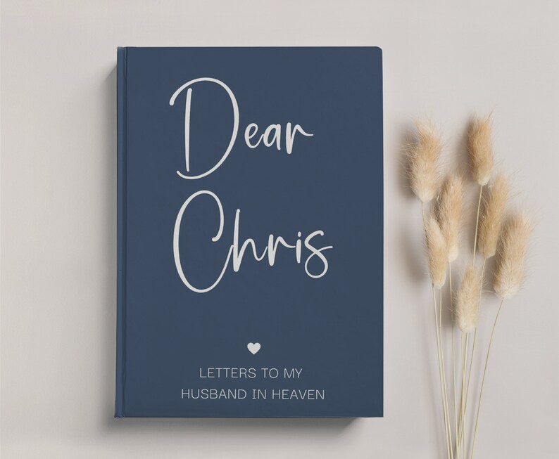 May include: A navy blue journal with the text "Dear Chris" in white script and the words "Letters to my Husband in Heaven" in white text. A small white heart is between the two lines of text.