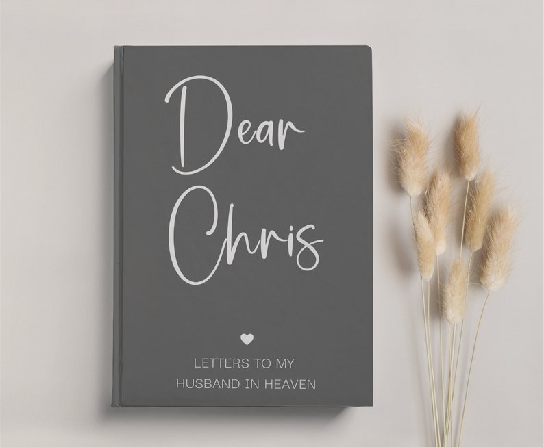 May include: A gray journal with the text "Dear Chris" in white lettering. Below the name, it says "Letters to my Husband in Heaven" with a small heart symbol.
