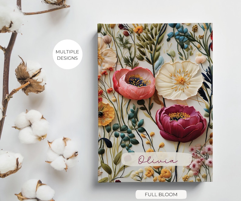 K&ouml;nnte beinhalten: Ein personalisiertes Notizbuch mit einem floralen Design mit rosa, wei&szlig;en und roten Blumen. Der Umschlag tr&auml;gt den Namen "Olivia" und den Text "Full Bloom".