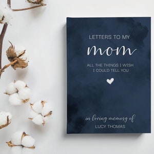 Peut inclure: Un journal bleu marine avec un motif de nuage blanc et le texte "LETTERS TO MY mom ALL THE THINGS I WISH I COULD TELL YOU" et un petit c&oelig;ur blanc. Le bas du journal porte le texte "in loving memory of LUCY THOMAS".