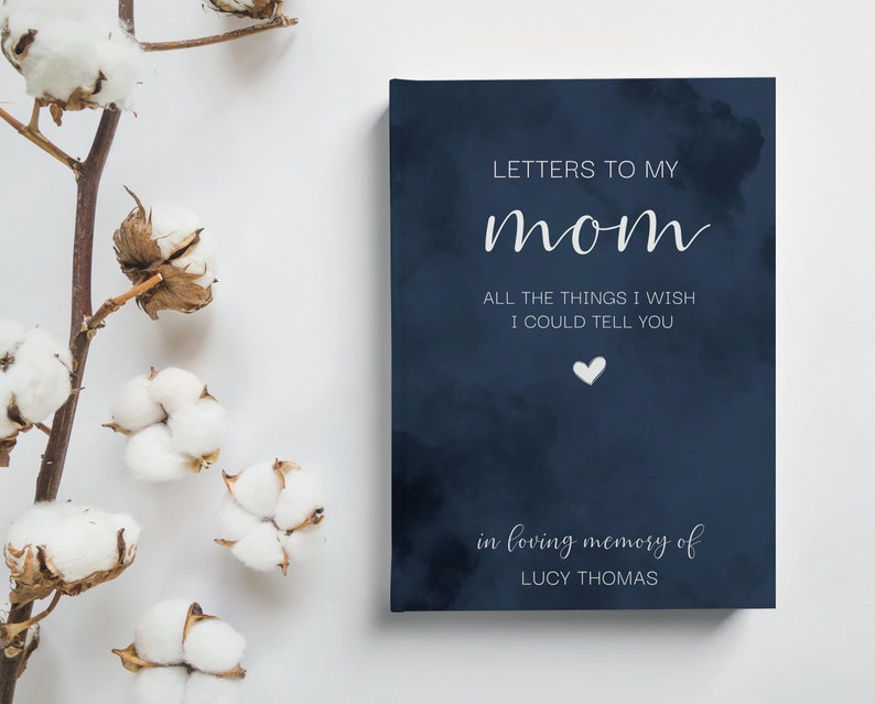 Peut inclure: Un journal bleu marine avec un motif de nuage blanc et le texte "LETTERS TO MY mom ALL THE THINGS I WISH I COULD TELL YOU" et un petit c&oelig;ur blanc. Le bas du journal porte le texte "in loving memory of LUCY THOMAS".