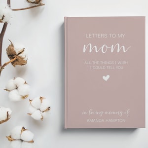 Peut inclure: Un journal rose poudr&eacute; avec le texte "LETTERS TO MY mom ALL THE THINGS I WISH I COULD TELL YOU" en lettres blanches. Un petit c&oelig;ur blanc se trouve sous le texte. Le bas du journal indique "in loving memory of AMANDA HAMPTON".