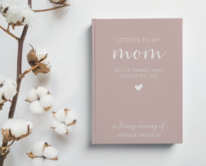 Peut inclure: Un journal rose poudr&eacute; avec le texte "LETTERS TO MY mom ALL THE THINGS I WISH I COULD TELL YOU" en lettres blanches. Un petit c&oelig;ur blanc se trouve sous le texte. Le bas du journal indique "in loving memory of AMANDA HAMPTON".