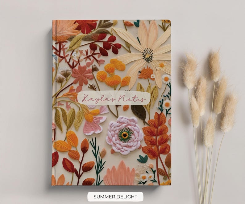 May include: A floral notebook with a cream background and a variety of colourful flowers, including orange, pink, yellow, and red. The notebook has the text "Layla's Notes" on the front cover and the words "SUMMER DELIGHT" printed below the image.