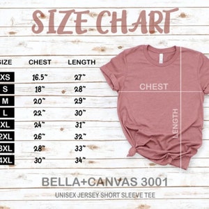 K&ouml;nnte beinhalten: Gr&ouml;&szlig;entabelle f&uuml;r ein Unisex-Jersey-T-Shirt mit kurzen &Auml;rmeln, die Brust- und L&auml;ngenma&szlig;e in Zoll f&uuml;r die Gr&ouml;&szlig;en XS bis 4XL zeigt. Die Tabelle ist auf einem hellen Holzhintergrund gedruckt.