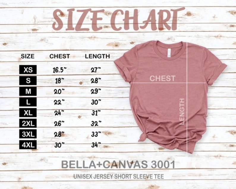 K&ouml;nnte beinhalten: Gr&ouml;&szlig;entabelle f&uuml;r ein Unisex-Jersey-T-Shirt mit kurzen &Auml;rmeln, die Brust- und L&auml;ngenma&szlig;e in Zoll f&uuml;r die Gr&ouml;&szlig;en XS bis 4XL zeigt. Die Tabelle ist auf einem hellen Holzhintergrund gedruckt.