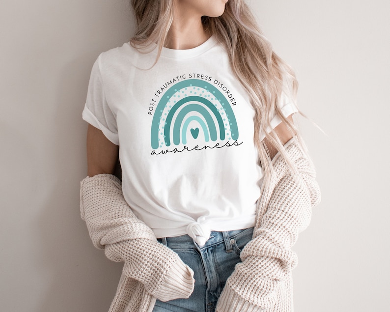 May include: White t-shirt with a teal blue rainbow graphic and the text "Post Traumatic Stress Disorder Awareness".