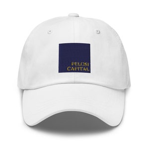 May include: White baseball cap with a navy blue square patch that says "Pelosi Capital" in gold lettering.