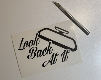 May include: A white sticker with a black silhouette of a rearview mirror and the text "Look Back At It" in a stylized font.