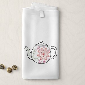 May include: White tea towel with a black and red embroidered teapot design. The teapot has a floral pattern with a red centre.