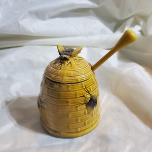 Vintage bijenkorfhoningpot met bij op deksel en honingstok