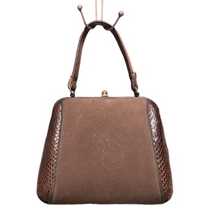 May include: A brown suede handbag with a snakeskin trim and a gold clasp.