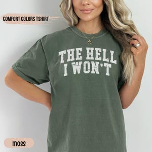 May include: A moss green t-shirt with the text "THE HELL I WON'T" printed in white.