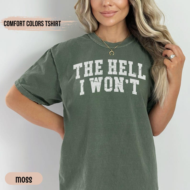 May include: A moss green t-shirt with the text "THE HELL I WON'T" printed in white.