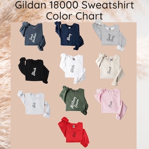 May include: Color chart for Gildan 18000 sweatshirts. The chart shows 10 different colors: Ash, Black, Dark Heather, Military Green, Navy, Pink, Red, Sand, Sport Grey, and White.
