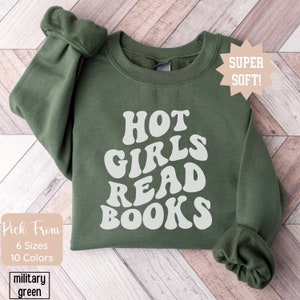 May include: A green sweatshirt with the text "HOT GIRLS READ BOOKS" in white, with a star-shaped tag that says "SUPER SOFT!" in the top right corner.