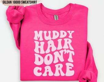 May include: Pink sweatshirt with the text "Muddy Hair Don't Care" in a retro font.