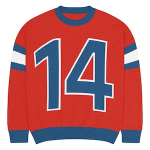 Puede incluir: Sudadera roja con el número 14 en azul y blanco. La sudadera tiene ribetes azules en el cuello, los puños y el dobladillo. Rayas blancas con ribetes azules en las mangas.