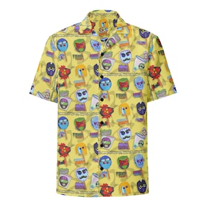 May include: Yellow short-sleeved button-down shirt with a repeating pattern of colorful cartoon faces, ice pops, and text. The shirt has a classic collar and button closure. The design includes various colors like blue, red, green, and yellow.