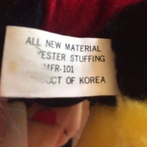 May include: A white tag with black text that reads "ALL NEW MATERIAL YESTER STUFFING MFR-101 PRODUCT OF KOREA".