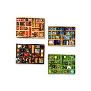 May include: Four rectangular wooden shadow boxes filled with assorted small decorative objects. One box features warm-toned items, another contains blue pieces, a third holds black and orange Halloween-themed trinkets, and the last displays green items.
