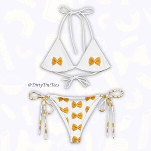 May include: White bikini with a triangle top and a high-cut bottom. The bikini is printed with a pattern of yellow pasta bows. The text "@DirtyTiniTees" is printed on the bottom.