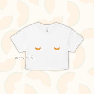 Könnte beinhalten: Weißes, bauchfreies T-Shirt mit einem Aufdruck von zwei Cantaloupe-Scheiben. Der Text "@DirtyTimiTees" ist unten auf dem Shirt aufgedruckt.