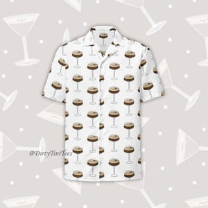 Könnte beinhalten: Weißes, kurzärmeliges Hemd mit Knöpfen und einem Muster aus braunen und weißen Espresso-Martini-Cocktails. Das Hemd hat einen Kragen und eine Tasche auf der linken Seite. Der Text '@DirtyTiniTees' ist in der linken unteren Ecke des Hemdes aufgedruckt.
