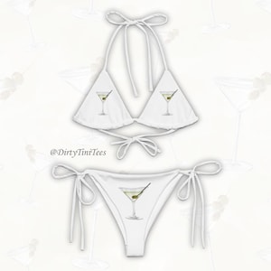 May include: White bikini with a halter top and a cheeky bottom. The top features a martini glass graphic on each side. The bottom features a martini glass graphic in the center.