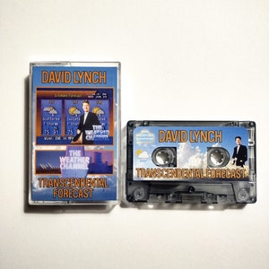 May include: A black cassette tape with a clear plastic case. The tape has a blue and white label with the text "DAVID LYNCH TRANSCENDENTAL FORECAST" and a picture of a man in a suit standing in front of a cloudy sky. The tape is a parody of The Weather Channel.