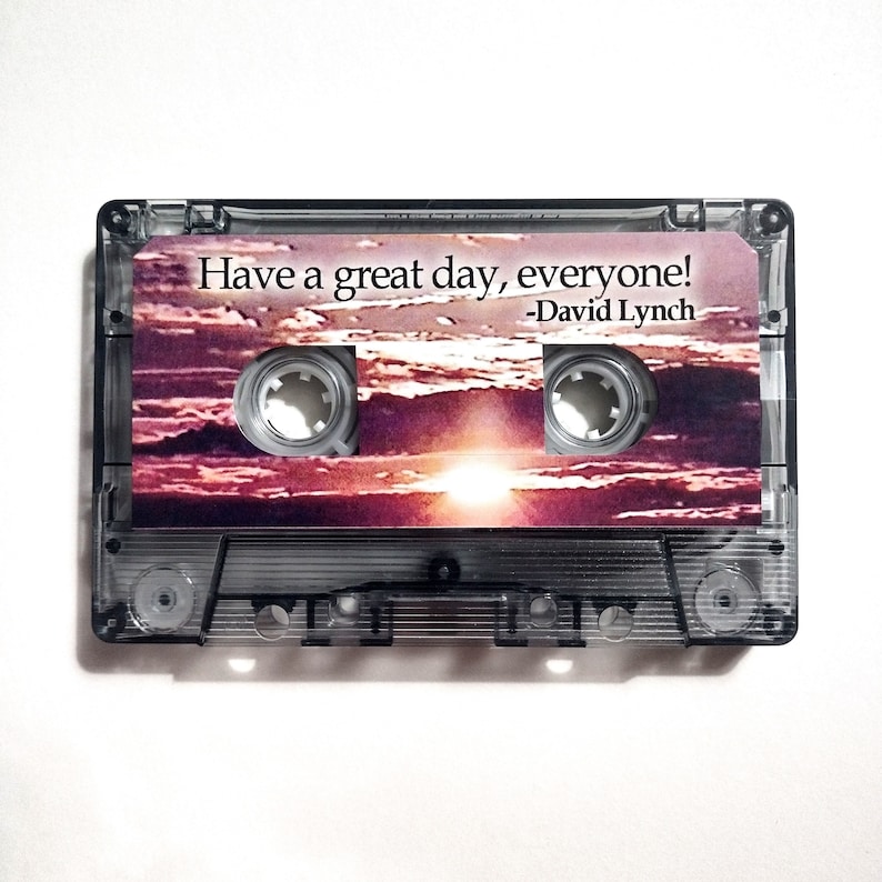 May include: A clear cassette tape with a sunset image and the text "Have a great day, everyone! -David Lynch" printed on the front.