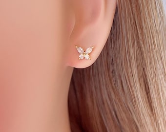 May include: A pair of gold butterfly earrings with clear cubic zirconia stones.