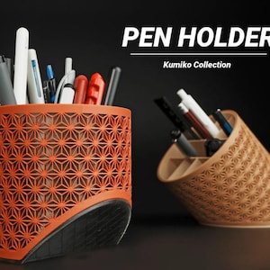 Op de afbeelding: Twee pennenbakjes, één oranje en één lichtbruin, met geometrische patronen. De oranje houder staat rechtop, terwijl de lichtbruine gekanteld is. Beide zijn gevuld met pennen en potloden. Tekst op de afbeelding luidt "PEN HOLDER" en "Kumiko Collection."
