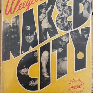 May include: A yellow book cover with the title "Weegee's Naked City" in black and white letters. The cover features a collage of black and white photographs of people and city scenes. The book cover also includes a credit for the photographer, Weegee, the famous.