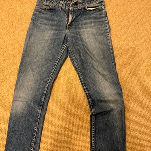 May include: A pair of blue denim jeans with a straight leg fit.