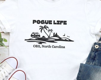 May include: White t-shirt with a black graphic design that says "Pogue Life" with a palm tree, a van, and a beach scene. The text "OBX, North Carolina" is below the graphic.