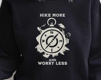 May include: Black sweatshirt with a white graphic design featuring a compass with the text "Hike More and Worry Less".