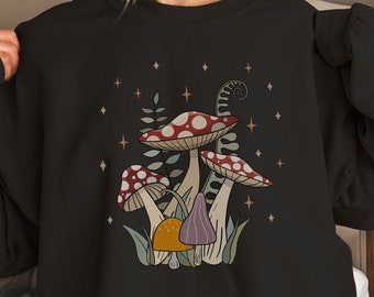 May include: Black sweatshirt with a mushroom graphic. The mushrooms are red, white, and brown with green leaves and stems. The graphic is surrounded by small white stars.
