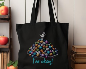 May include: Black tote bag with a graphic of a hand reaching out of a pile of colorful yarn balls. The text "I'm okay!" is printed below the graphic.