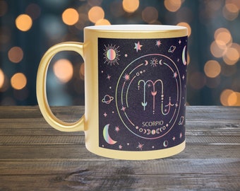 May include: Gold mug with a black and gold design featuring the zodiac sign Scorpio with celestial symbols and the text "Scorpio".