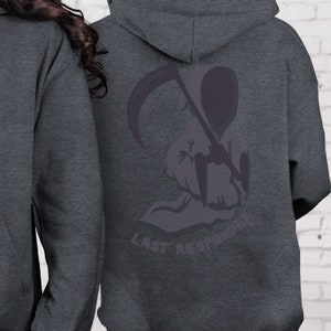 K&ouml;nnte beinhalten: Ein dunkelgrauer Kapuzenpullover mit einer Grafik einer Kapuzenfigur, die eine Sense h&auml;lt. Der Text "Last Responder" ist unter der Grafik gedruckt.