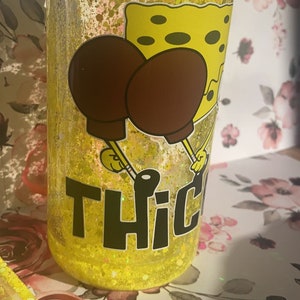 May include: Yellow glitter tumbler with a cartoon image of Spongebob Squarepants holding a spatula and the text "THIC" on the bottom.