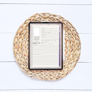 May include: A digital tablet with a book tracker template on the screen. The template includes fields for title, author, genre, number of pages, start date, end date, tropes, format, part of a series, series title, book number, and thoughts. The tablet is on a woven straw mat.