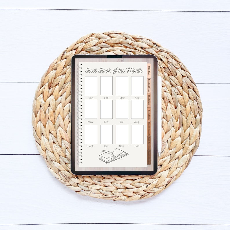 Op de afbeelding: Een digitale planner op een geweven placemat met de titel "Beste boek van de maand". De planner heeft 12 vakjes voor elke maand van het jaar, met een boekpictogram onderaan.