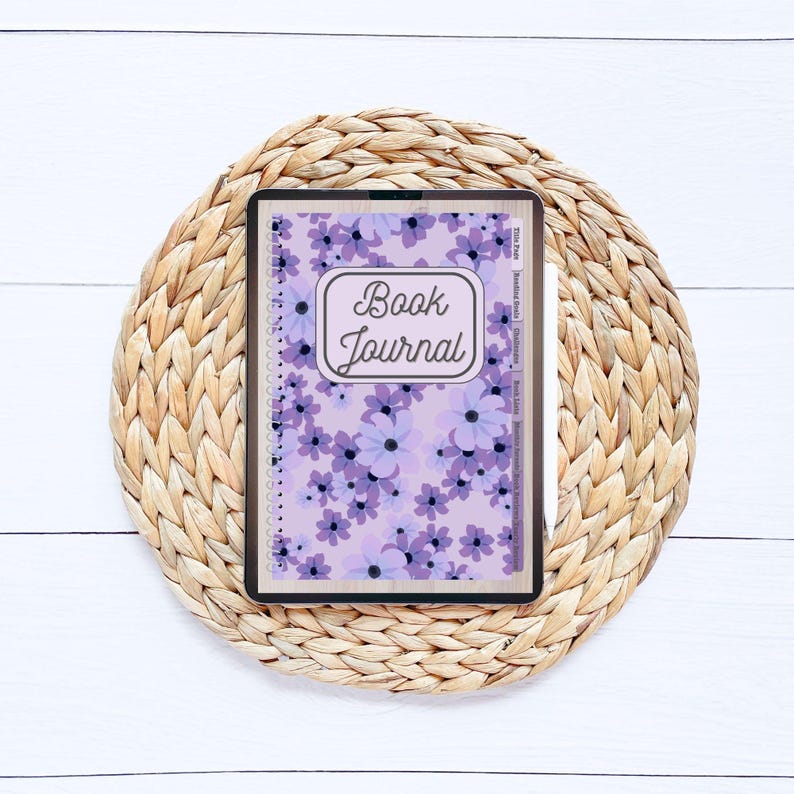 May include: A purple and white floral patterned book journal with the text "Book Journal" in a brown rectangle on the cover.